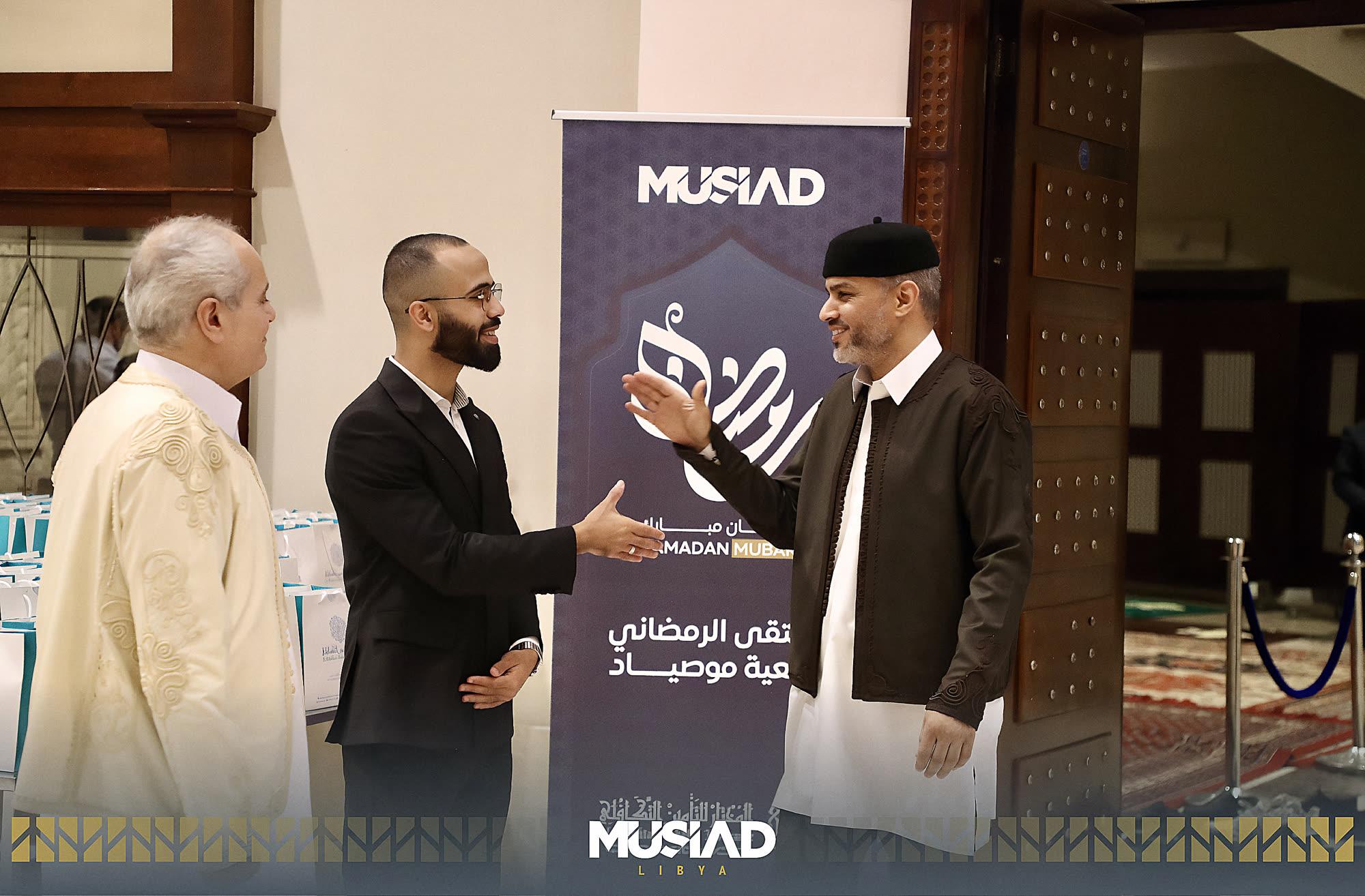 Conversation at a MUSIAD event stand during a business gathering